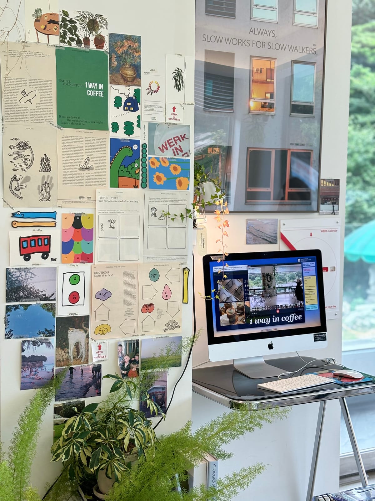 A brand inspiration board on a studio wall beside a computer